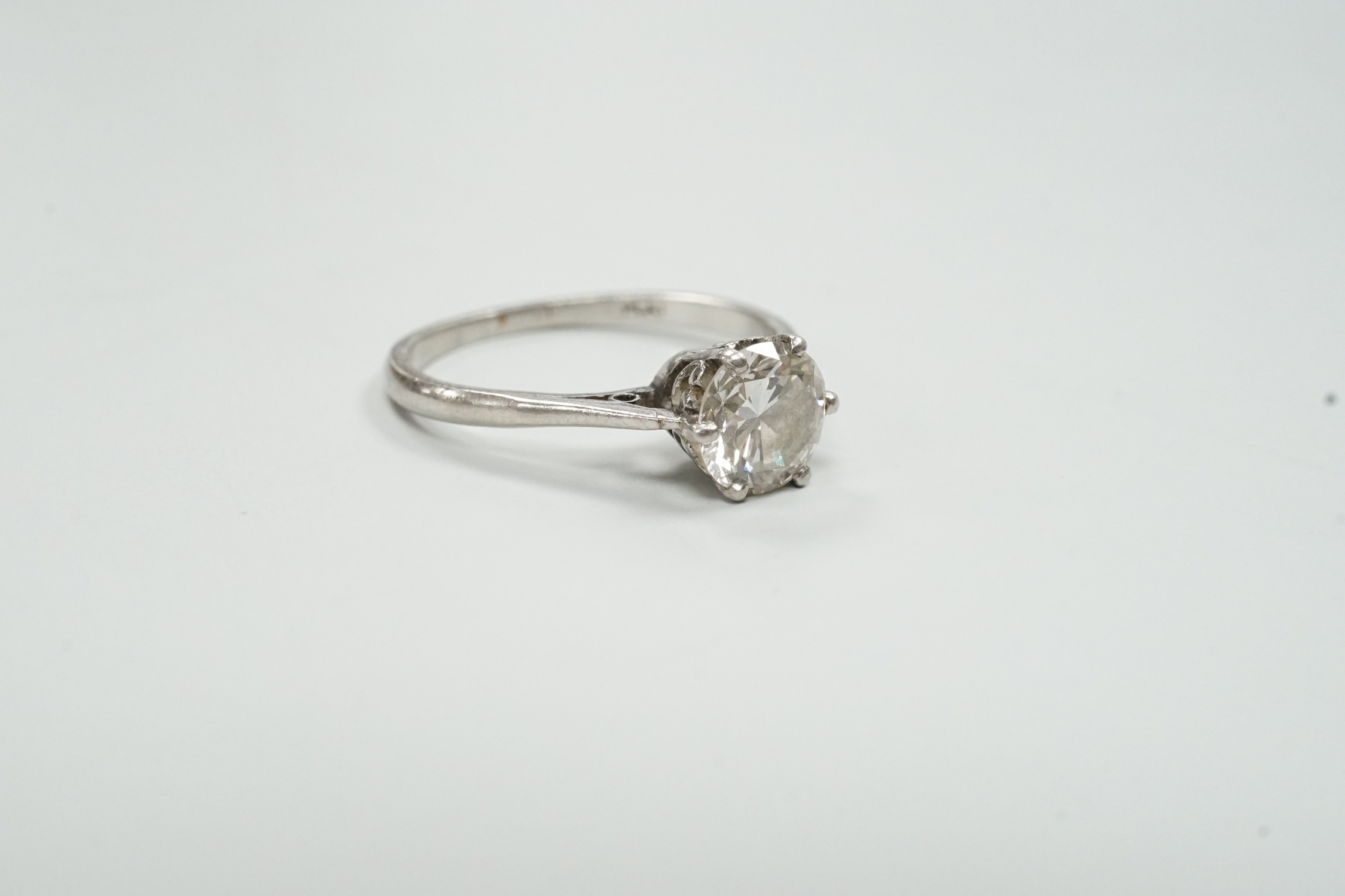 A white metal (stamped plat) and solitaire diamond set ring, size M, gross weight 3.1 grams